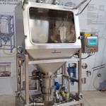 Emptying system for bags on loading cells with integrated washing system